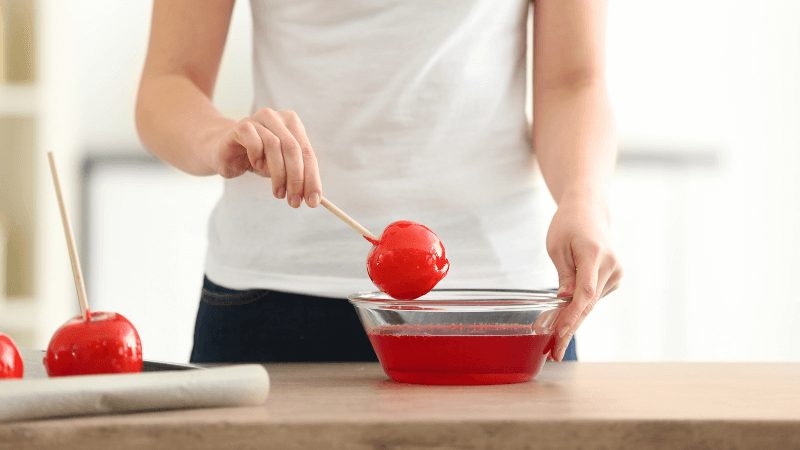 Woman preparing Candy apples in kitchen