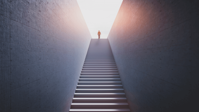 A man at the top of a long flight of stairs