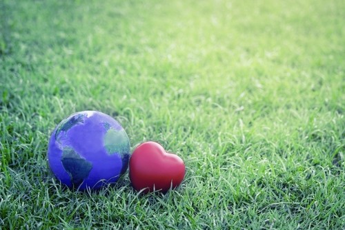 Earth with red heart on green grass, save the world, love and protect our planet, and environmental friendly concept
