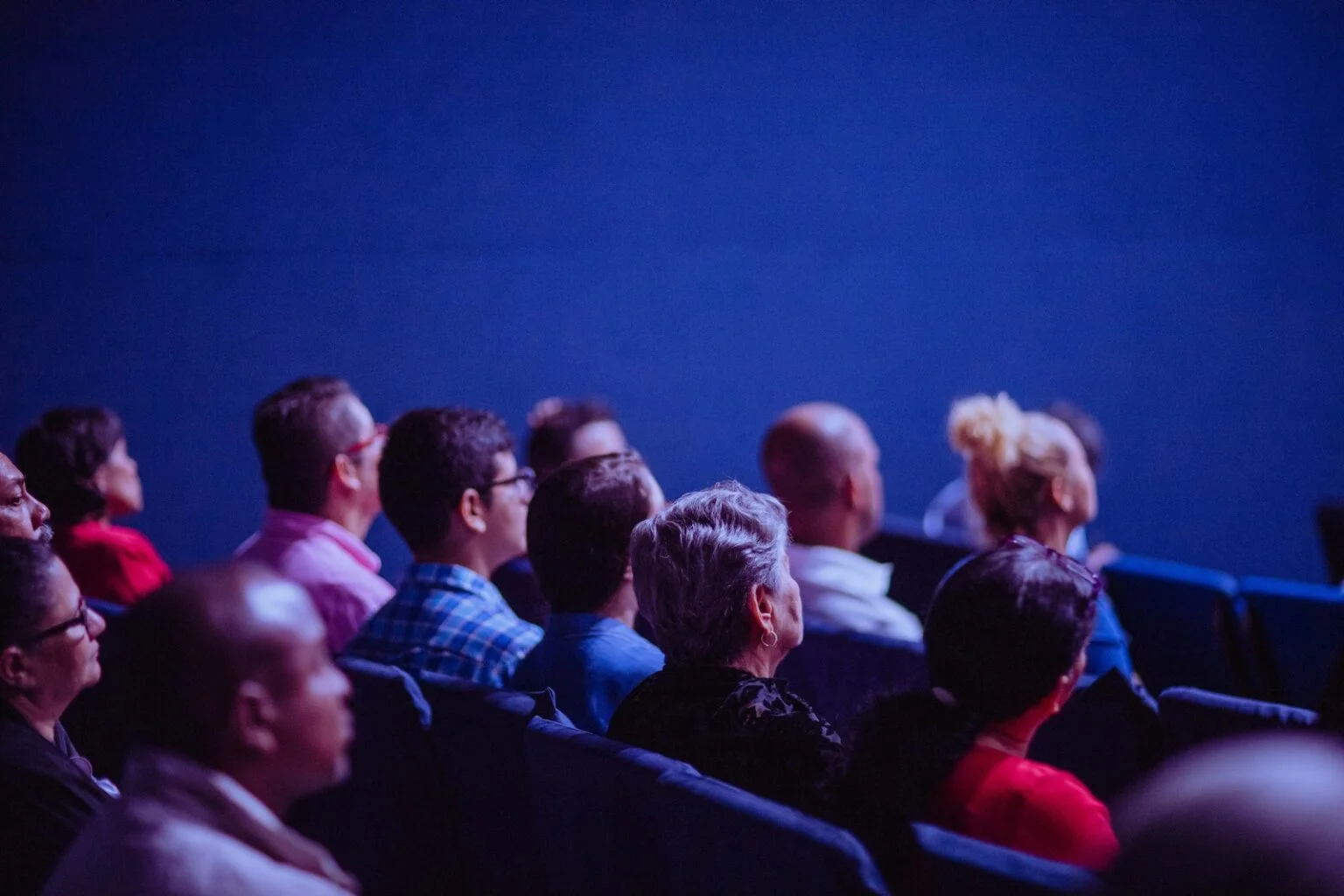 A diverse group of people gathered around a table engaged in discussion, representing the process of understanding and identifying the right target audience for influencer marketing.