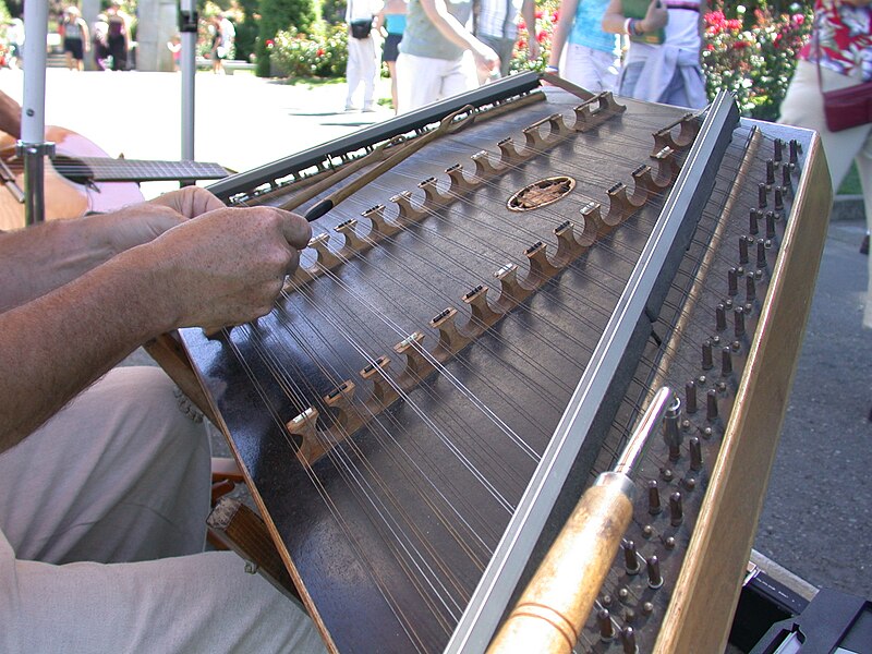 A Man playing music on a Hammered dulcimer