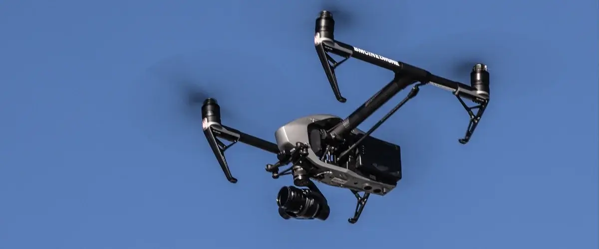 A drone flying above a scenic landscape capturing high-resolution photos and video.