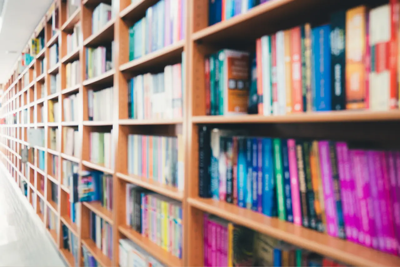 A long stack of business books on top of a desk