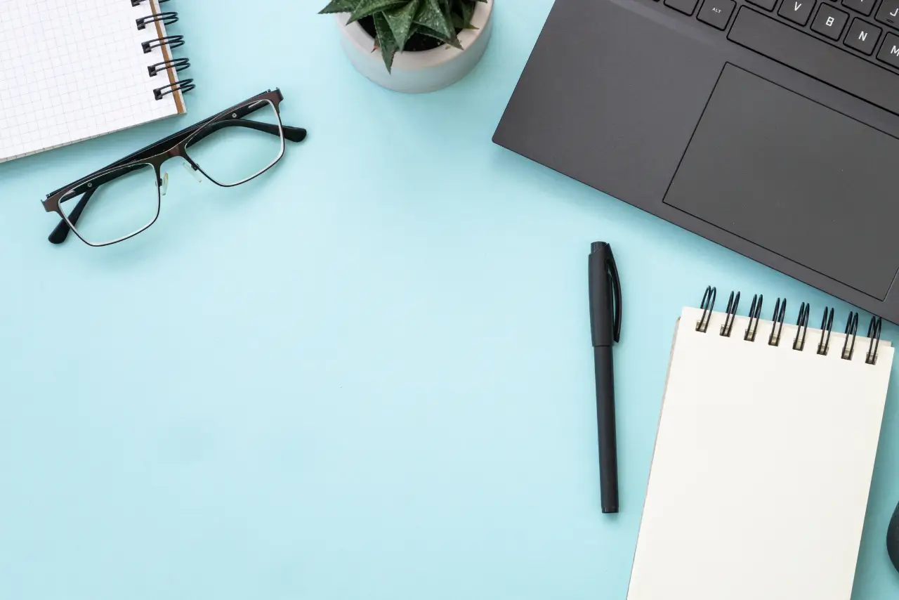 Flat lay of phone, notepad, pen, and coffee cup on a desk