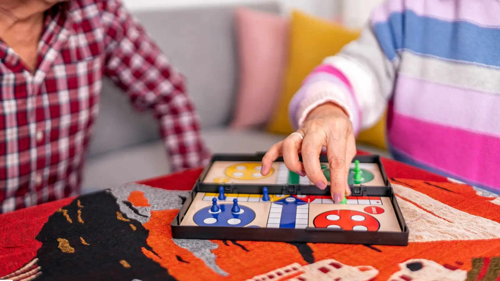 A man and woman playing a boardgame on living room floor