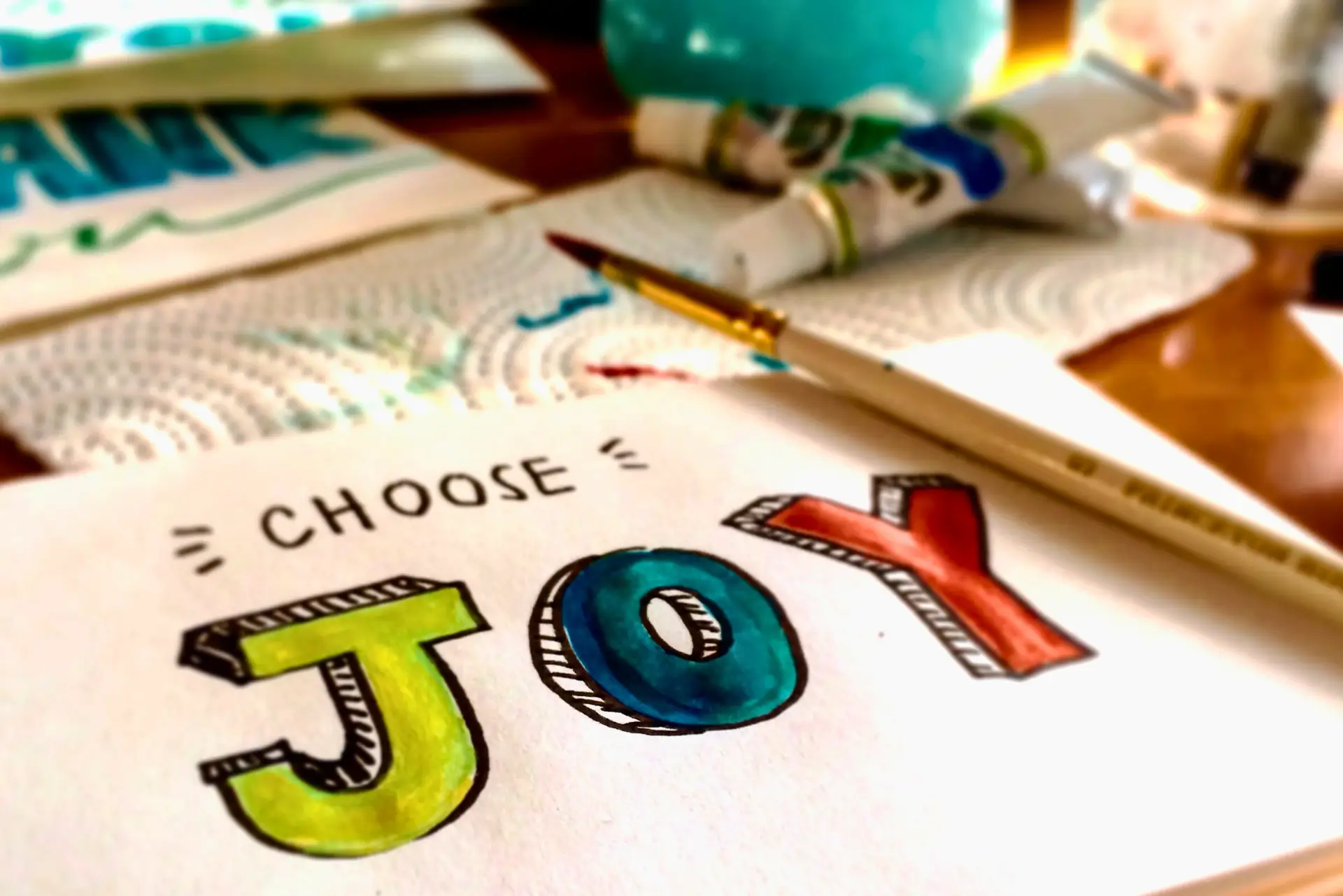 The word Joy painted on a canvas
