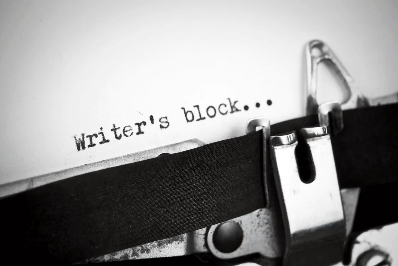 Writer overcoming creative block while brainstorming ideas and writing in a notebook